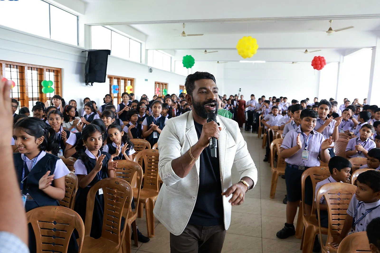 Arun Guinness singing as he walks through a hall of students