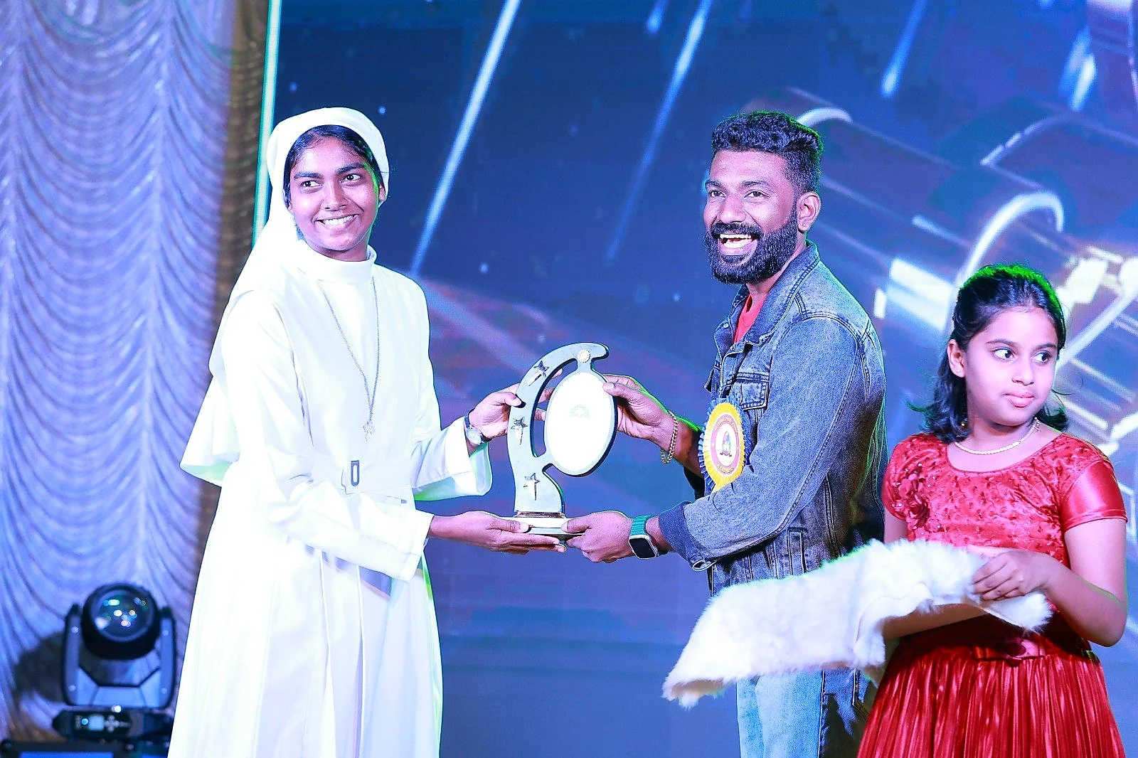 Arun Guinness receiving an award from a guest on a school stage