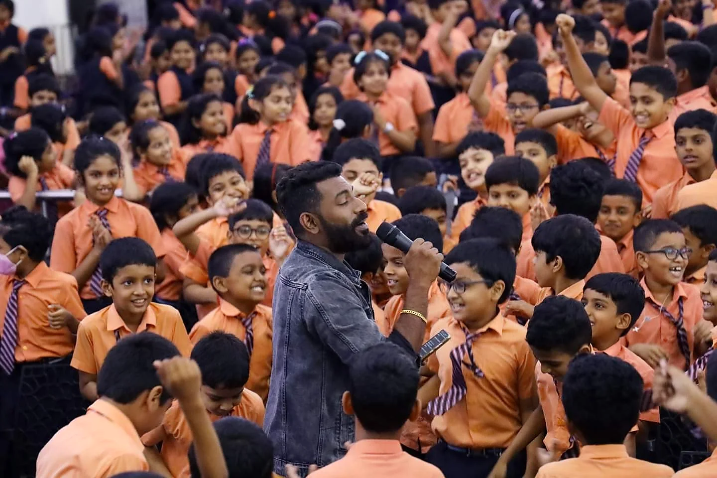Arun Guinness singing in the middle of a cheering student audience